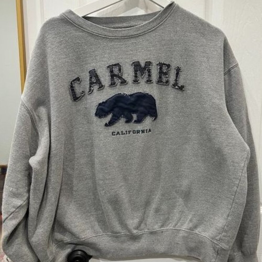 A grey crewneck, with navy blue letters.